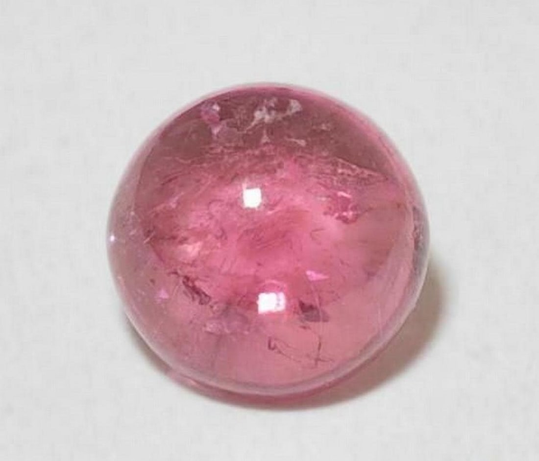 1.26 ct Natural Medium Pink Tourmaline - Round Cabochon: 1.26 ct Natural Medium Pink Tourmaline - Round Cabochon Introducing the Natural Medium Pink Tourmaline, a beautiful gemstone showcasing a soft yet vibrant pink hue. Its round cabochon shape enhances