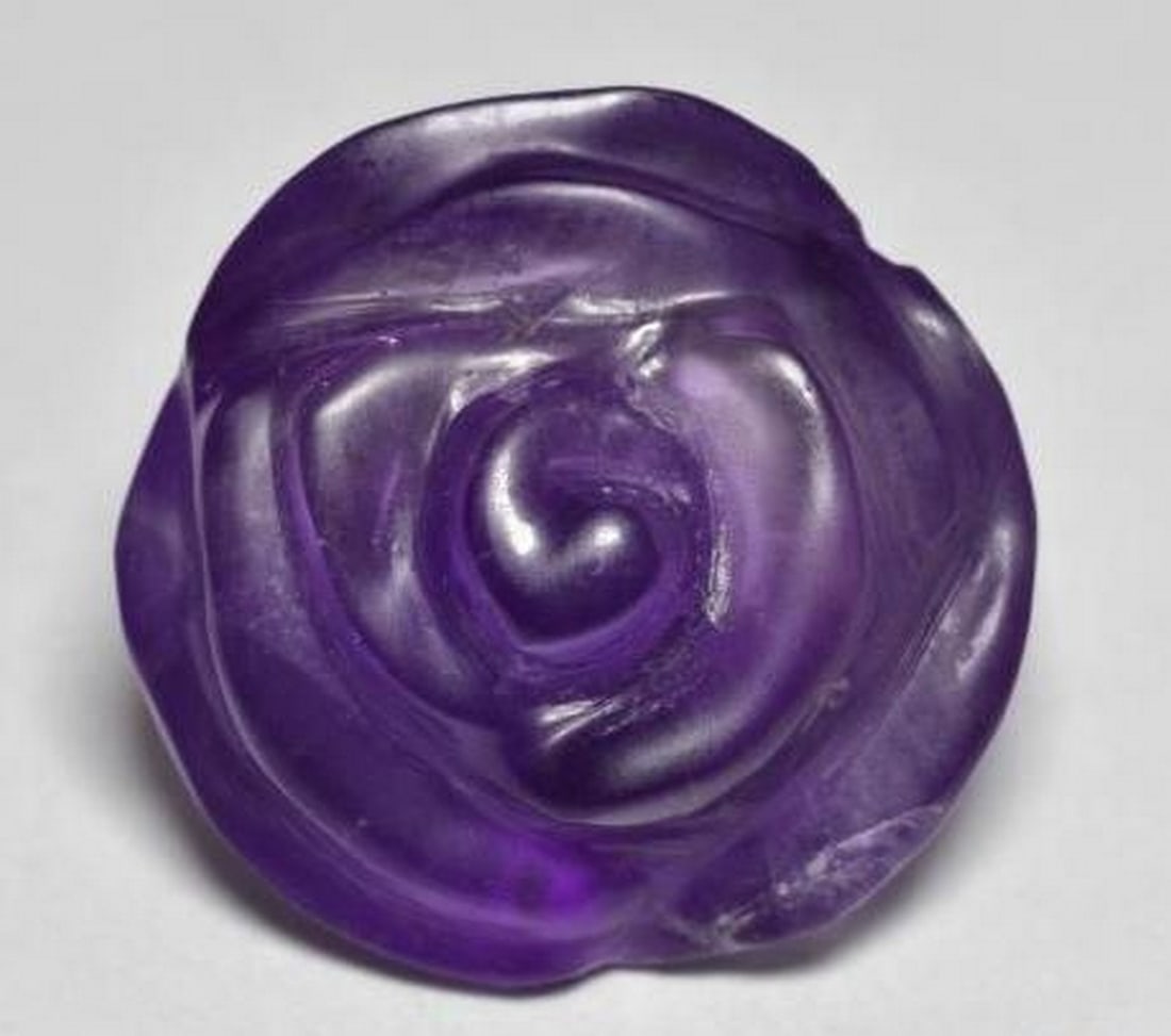 Medium Violet Amethyst Rose Carved Gemstone: Medium Violet Amethyst Rose Carved Gemstone Carved from natural amethyst in a soft medium violet hue, this loose gemstone features a beautifully sculpted rose in full bloom. The graceful curves and