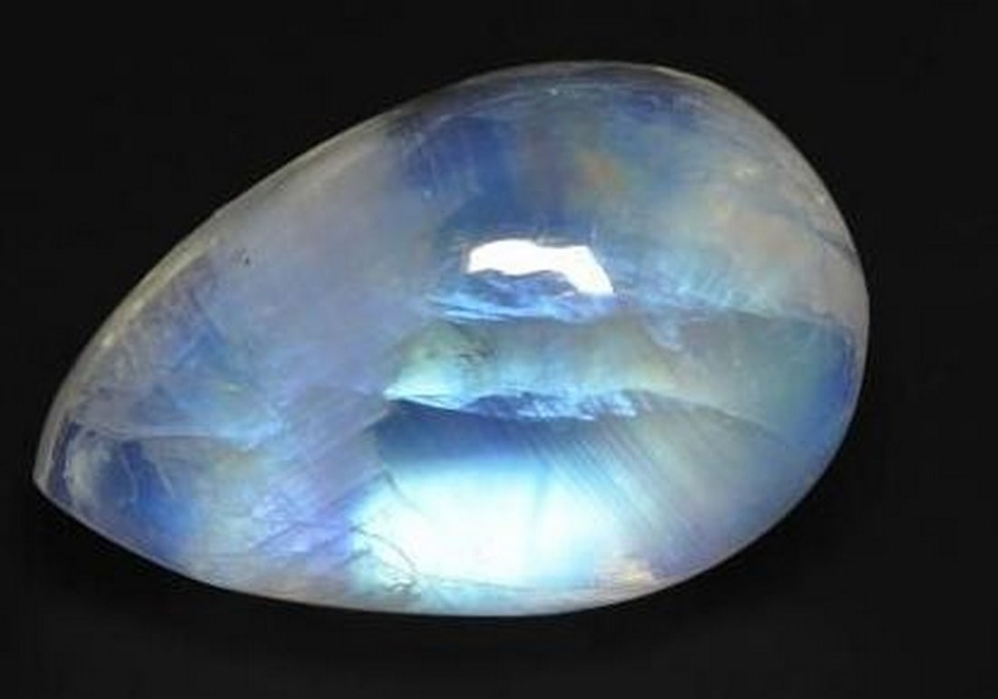Loose Rainbow Moonstone Pear Cabochon with Bluish White Glow: Loose Rainbow Moonstone Pear Cabochon with Bluish White Glow Ethereal and enchanting, this loose Rainbow Moonstone features a smooth pear-shaped cabochon cut and a soft bluish white body color. When l