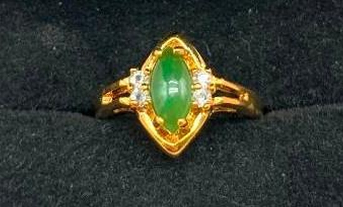 Green Jade Cat's Eye Ring with White Crystals: Green Jade Cat's Eye Ring with White Crystals Gracefully eye-catching, this ring features a polished green jade cat's eye stone that shimmers with a natural, silky glow. The oval gem is accented by fo