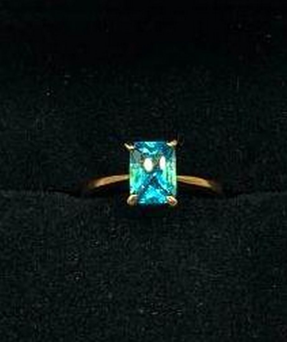 Cushion Cut Blue Stone Ring: Cushion Cut Blue Stone Ring Bold yet refined, this ring features a striking cushion cut blue stone that radiates depth and brilliance from every angle. The vibrant gemstone is set atop a gleaming 18KT