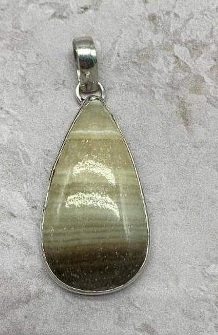 Silver-Plated Zebra Calcite Gemstone Pendant: Silver-Plated Zebra Calcite Gemstone Pendant Bring a touch of nature's elegance to your style with this Silver-Plated Zebra Calcite pendant. The gemstone features a beautiful blend of soft creams and