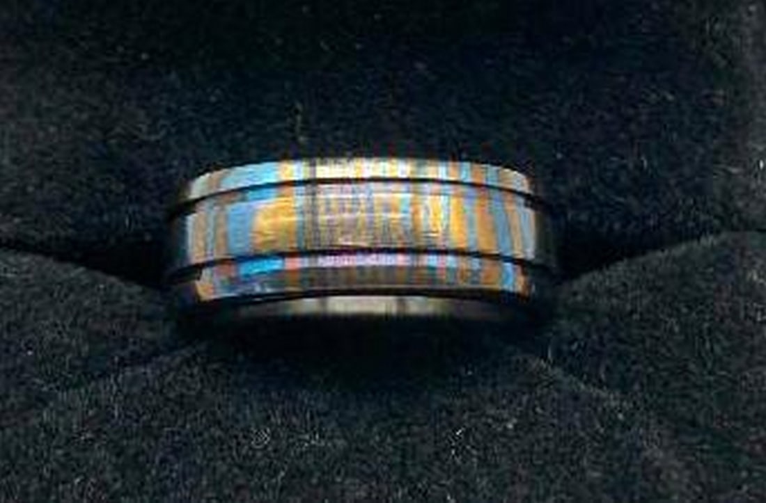 Timascus Ring Blue & Orange Swirl: Timascus Ring Blue & Orange Swirl This eye-catching Timascus ring features vivid swirls of blue and orange that dance across its surface in a stunning display of color and movement. Two finely carved