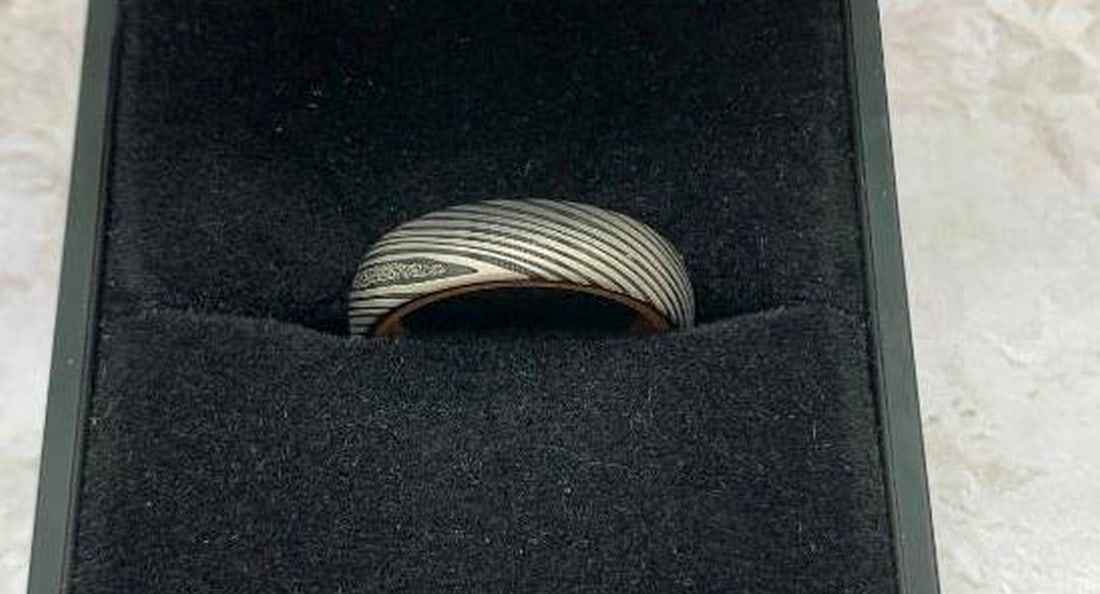 Men's Light Gray Damascus Steel Ring with Whiskey Barrel Wood Interior: Men's Light Gray Damascus Steel Ring with Whiskey Barrel Wood Interior Crafted for the man who appreciates heritage and strength, this ring features a striking light gray Damascus steel exterior,