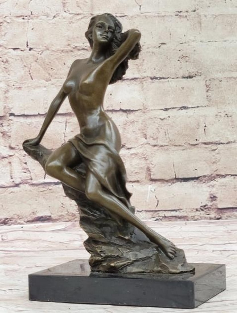 Bronze Sculpture of Woman on Rock: Bronze Sculpture of Woman on Rock Graceful and contemplative, this bronze sculpture captures a serene moment of quiet strength and natural beauty. A nude woman reclines on her side atop a slanted rock