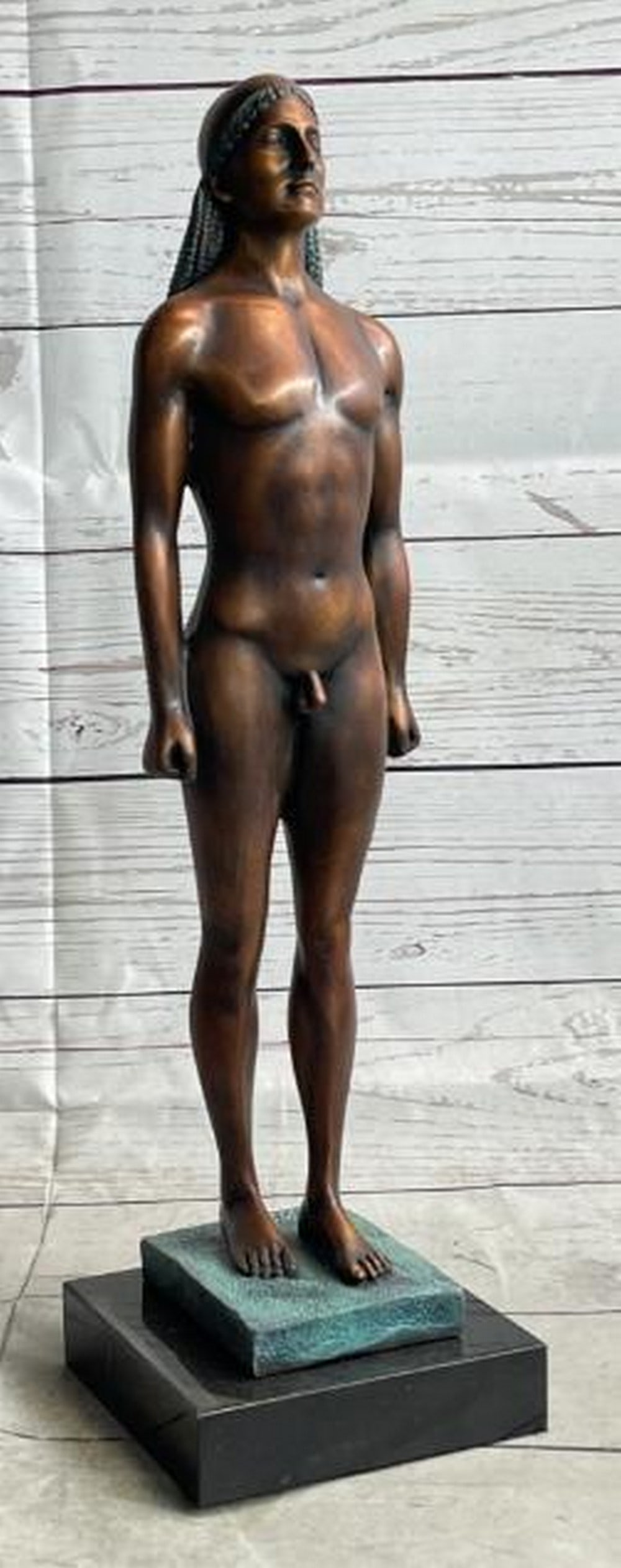 Ancient Kouros: Nude Male Greek Bronze Statue: Ancient Kouros: Nude Male Greek Bronze Statue Inspired by the timeless elegance of classical antiquity, this bronze sculpture is a reproduction of an ancient Greek Kouros figure. A stylized nude male 