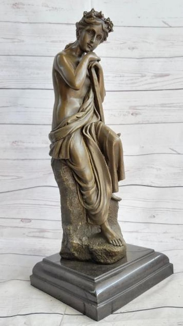 Semi-Nude Greek Goddess with Pickaxe Bronze Sculpture: Semi-Nude Greek Goddess with Pickaxe Bronze Sculpture A striking blend of classical beauty and symbolic power, this bronze sculpture depicts a semi-nude Greek goddess seated in quiet repose, her head 