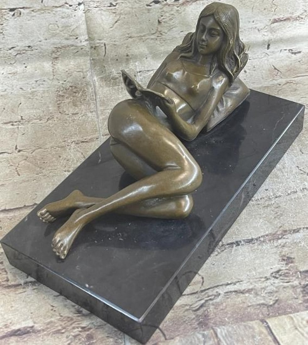 Storytime Serenity: Reproduction Bronze Sculpture: Storytime Serenity: Reproduction Bronze Sculpture A heartwarming reproduction bronze sculpture capturing a quiet, timeless moment of a girl lying down, fully absorbed in the pages of a book. Her relax