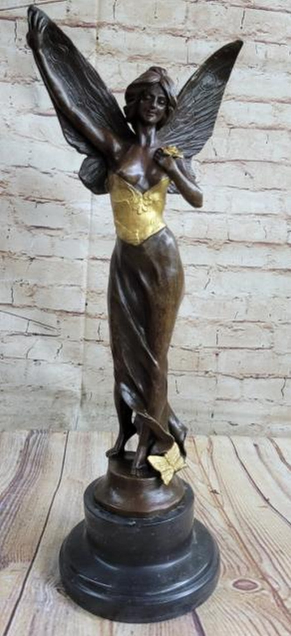 Golden Grace: Winged Angel Fairy Bronze Statue: Golden Grace: Winged Angel Fairy Bronze Statue A sensual and enchanting reproduction bronze statue depicting a winged angel fairy in a graceful, alluring pose. With delicate wings unfurled and a flowi