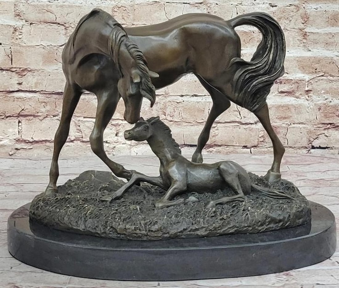 Mare and Foal Bronze Sculpture: Mare and Foal Bronze Sculpture This touching reproduction bronze sculpture captures the heartfelt connection between a mare and her foal. The foal rests gently on the ground, head lifted in quiet trus