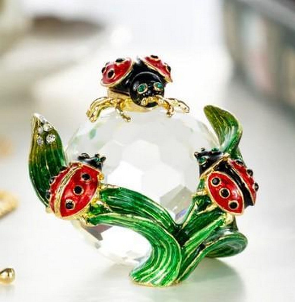 Charming Ladybugs on Crystal Trinket: Charming Ladysbugs on Crystal Trinket Adorned with adorable ladybugs, this crystal trinket box blends playful charm with sparkling elegance. The clear, faceted crystal base reflects light beautifully,