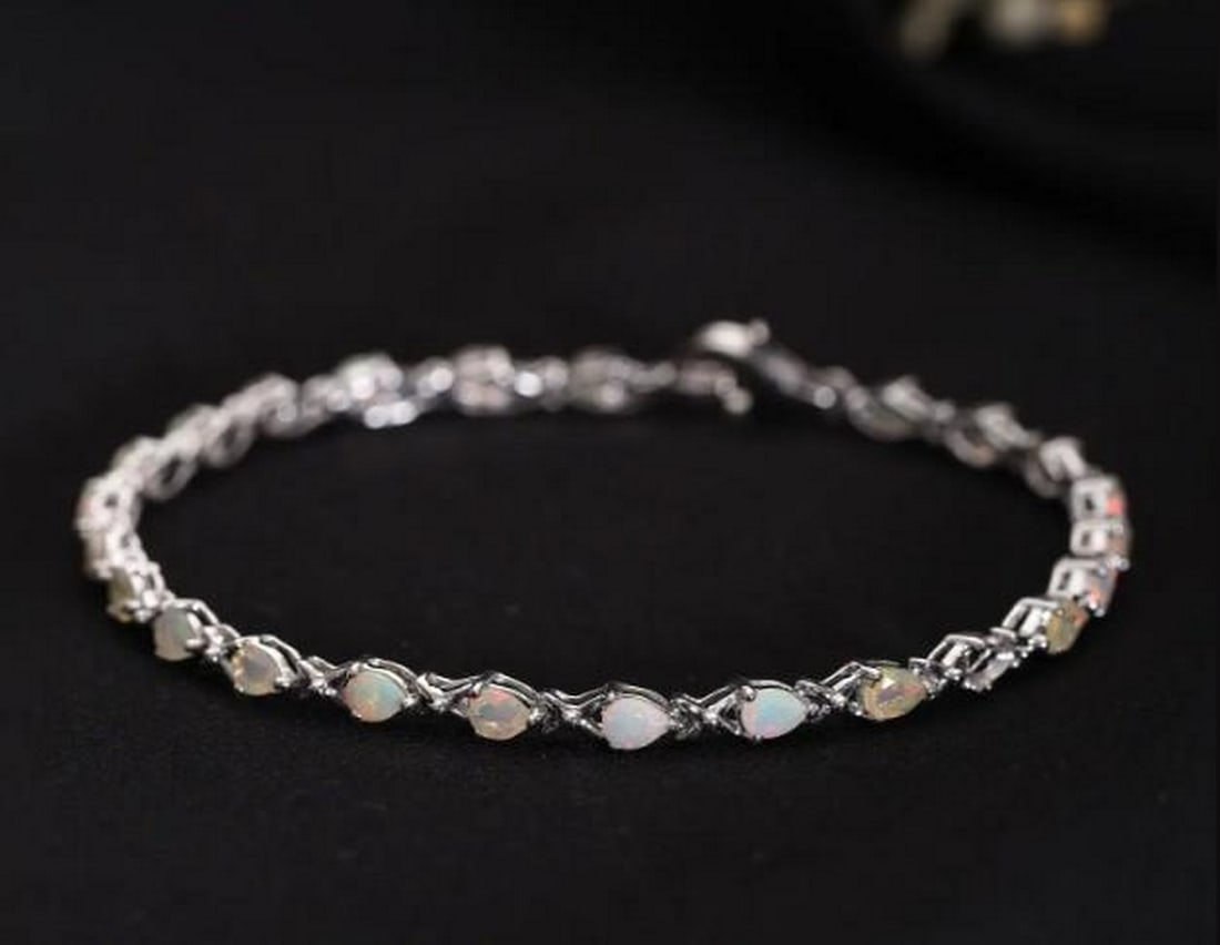 Aurora Drops: Aurora Drops - Handcrafted Teardrop Ethiopian Opal Bracelet Adorn your wrist with a cascade of ethereal beauty. This exquisite bracelet showcases the captivating allure of Ethiopian opals, each stone 