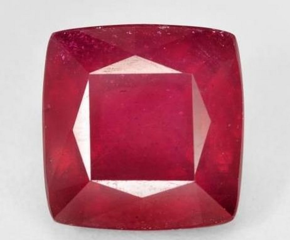 Dark Red Ruby Cushion-Cut Gemstone: Dark Red Ruby Cushion-Cut Gemstone Rich and regal, this cushion-cut ruby glows with a deep, dark red hue that embodies passion and timeless luxury. The classic cushion shape enhances its natural brill