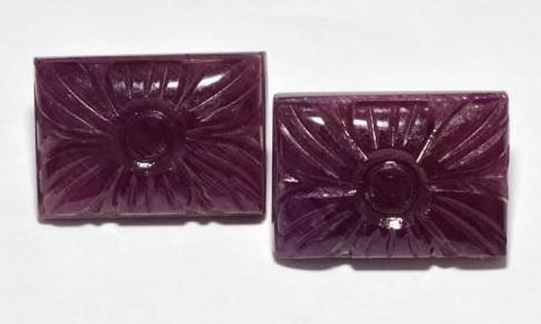 Set of Two Deep Red Ruby Flower Carvings in Rectangular Cut: Set of Two Deep Red Ruby Flower Carvings in Rectangular Cut This exquisite pair of loose ruby gemstones features rich deep red hues, each cut into a rectangular shape and intricately carved with a del