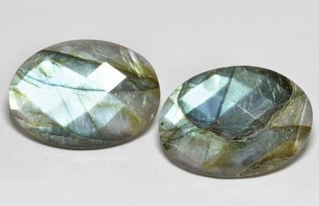 Twin Aurora Pair of Oval Checkerboard Labradorite Gems: Twin Aurora Pair of Oval Checkerboard Labradorite Gems This enchanting pair of Labradorite gemstones showcases the mystique of nature's light show. Each stone is expertly cut in an oval checkerboard
