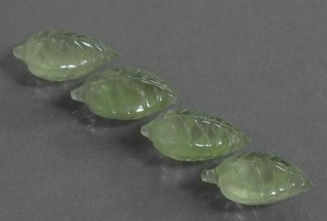 Set of Four Prehnite Medium Green Leaf-Carved Gemstones: Set of Four Prehnite Medium Green Leaf-Carved Gemstones This elegant set includes four loose gemstones, each meticulously carved into the graceful shape of a leaf from soft, translucent medium green P