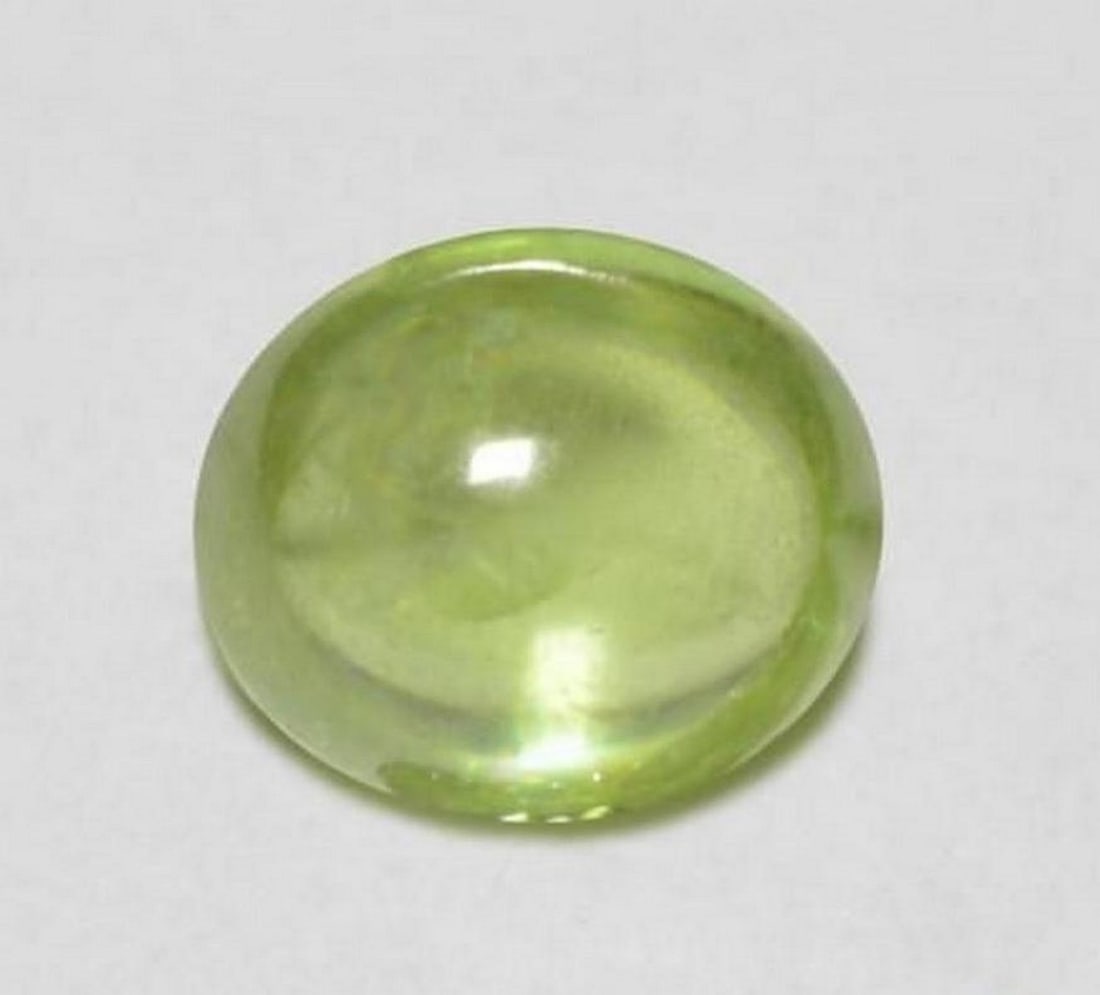 0.89 ct Natural Light Lively Green Sphene - Oval Cabochon: 0.89 ct Natural Light Lively Green Sphene - Oval Cabochon Introducing the Natural Light Lively Green Sphene, a dazzling gemstone that brings vibrant energy to any jewelry collection. Its lively light 