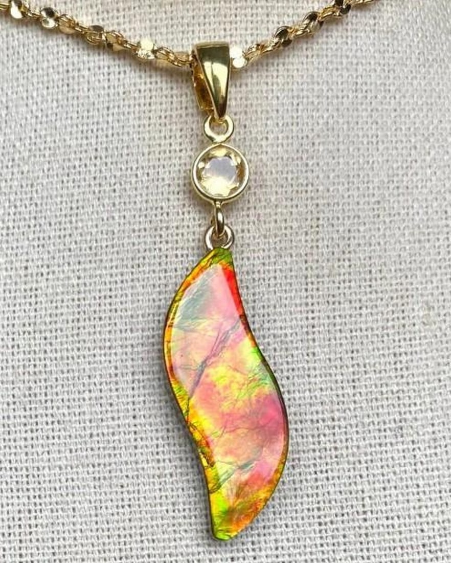 Ancient Flame Ammolite Pendant: Ancient Flame Ammolite Pendant This Ammolite pendant is a lovely S shaped stone in autumn colors along with a citrine accent. The gem measures in at 28mm x 10mm and hangs from a sterling silver pin