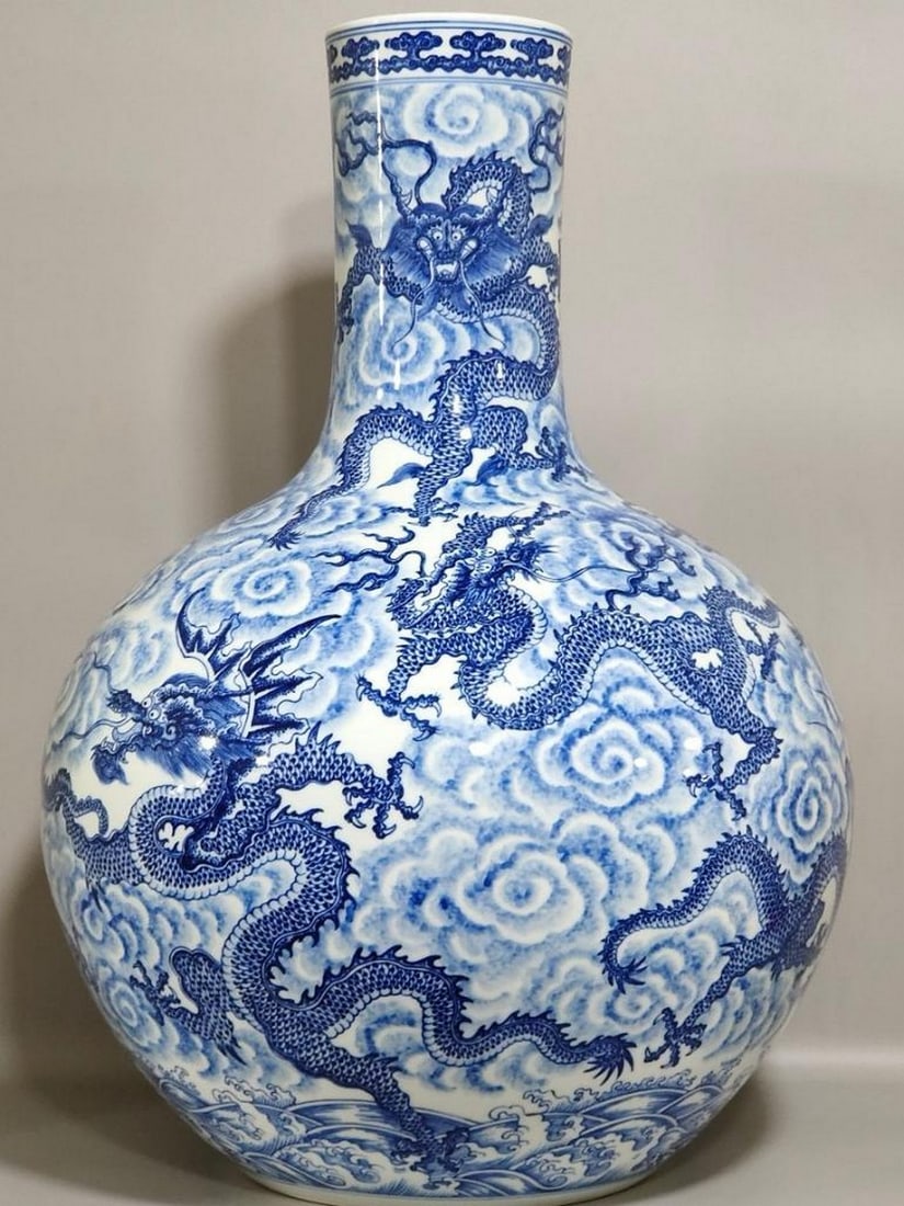 Blue and White Nine Dragons Celestial Vase: Blue and White Nine Dragons Celestial Vase This magnificent large vase features nine dynamic dragons soaring through swirling clouds, masterfully painted in rich cobalt blue. Symbolizing power, streng