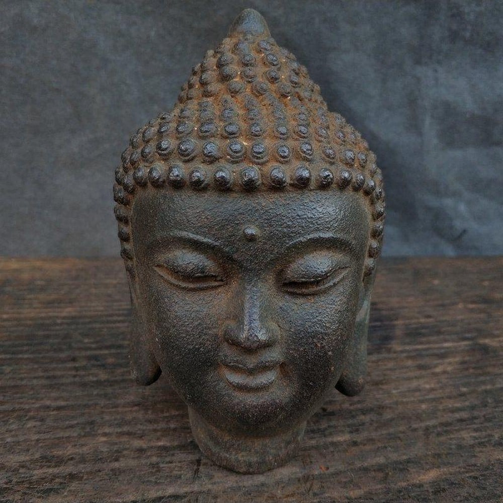 Antique Iron Shakyamuni Buddha Head: Antique Iron Shakyamuni Buddha Head This antique iron head of Shakyamuni Buddha captures the essence of serenity and enlightenment. The detailed craftsmanship highlights the peaceful expression,