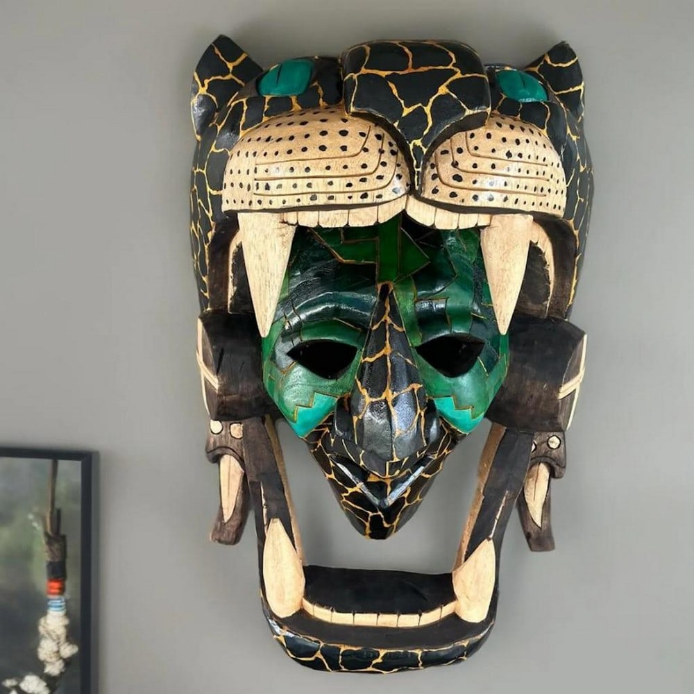 Jaguar Warrior Hand-Carved Cedar Mask: Jaguar Warrior Hand-Carved Cedar Mask This hand-carved wooden mask depicts a Jaguar Warrior inspired by Mayan and Aztec traditions, featuring detailed carving and dimensional elements that reflect tra