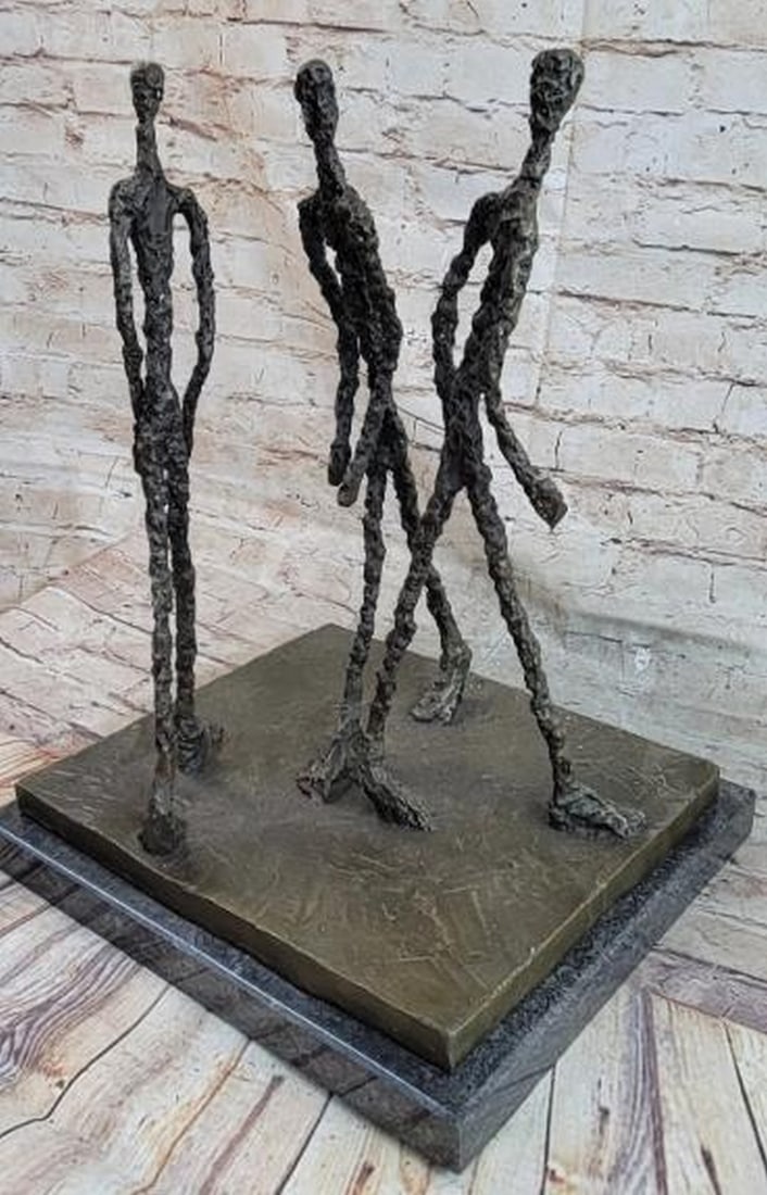 The Walkers: Reproduction Bronze Sculpture: The Walkers: Reproduction Bronze Sculpture This evocative bronze sculpture, bearing the signature of Alberto Giacometti, features three elongated male figures walking together in unison. Rendered in G