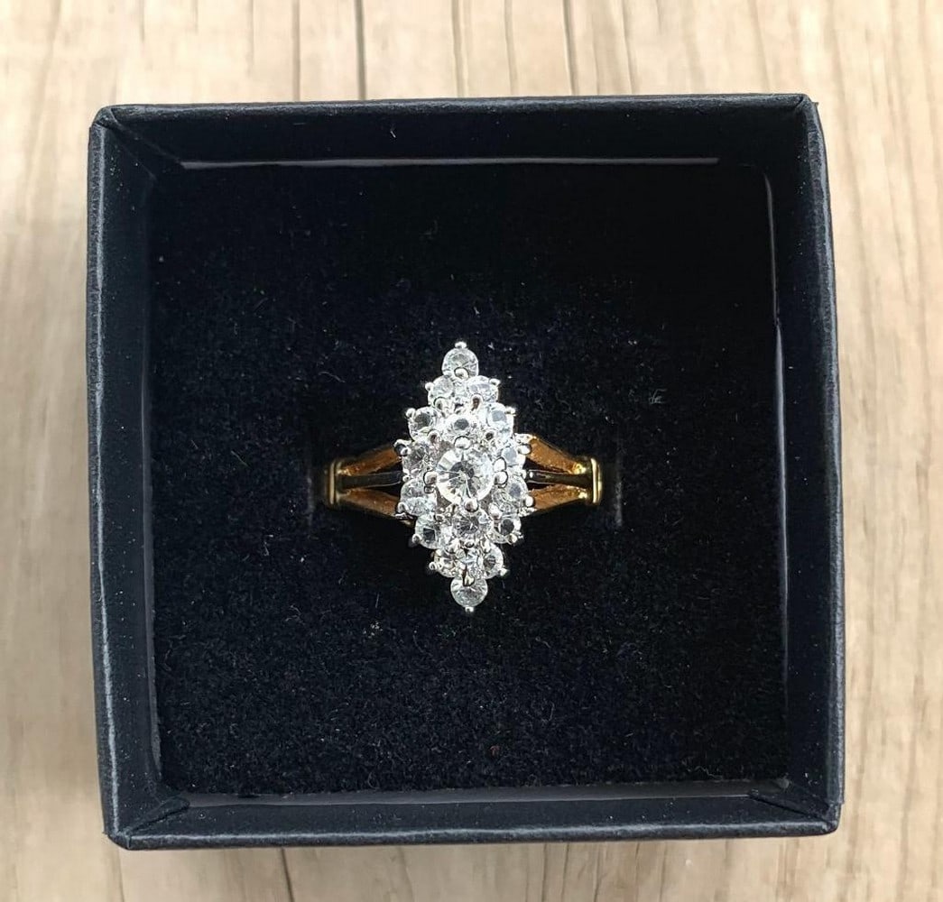 Royal Cluster Moissanite Ring: Royal Cluster Moissanite Ring Sophisticated round-cut moissanite cluster ring set in rich yellow gold, elegantly presented in a black velvet box. The center moissanite is surrounded by a dazzling