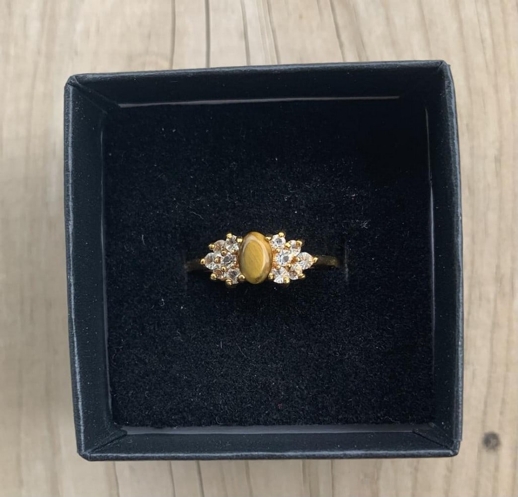 Golden Gaze Ring: Golden Gaze Ring This classic ring features an oval-cut tiger's eye gemstone, prized for its golden-brown bands and natural chatoyancy. Set in a warm gold-tone band, the stone shimmers with depth and