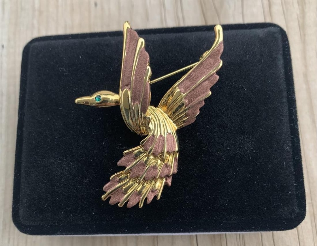 Elegant Gold and Brown Bird Brooch: Elegant Gold and Brown Bird Brooch Graceful and eye-catching, this Dolphin Ore bird brooch features a charming avian design finished in rich gold tone. Delicate detailing and sparkling crystal