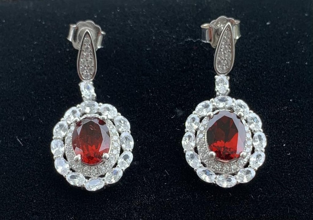 Oval Mozambique Garnet Stud Earrings in Sterling Silver: Oval Mozambique Garnet Stud Earrings in Sterling Silver These sterling silver earrings feature a pair of 8x6mm oval-cut Mozambique garnets, prized for their rich crimson hue and natural depth. Set in 