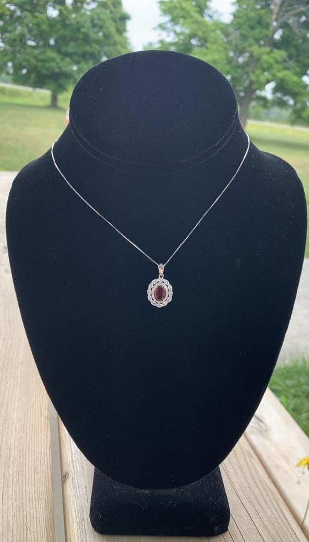 Oval Mozambique Garnet Pendant Necklace in Sterling Silver: Oval Mozambique Garnet Pendant Necklace in Sterling Silver Crafted in 925 sterling silver, this 18-inch necklace showcases an 8x6mm oval-cut Mozambique garnet - renowned for its deep, fiery red hue. T