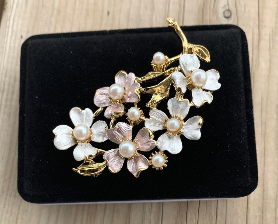 Pink and White Floral Brooch with Inlaid White Pearl Accents: Pink and White Floral Brooch with Inlaid White Pearl Accents White pearls are thought to symbolize innocence, new beginnings, beauty and sincerity. They have also been said to signify femininity,