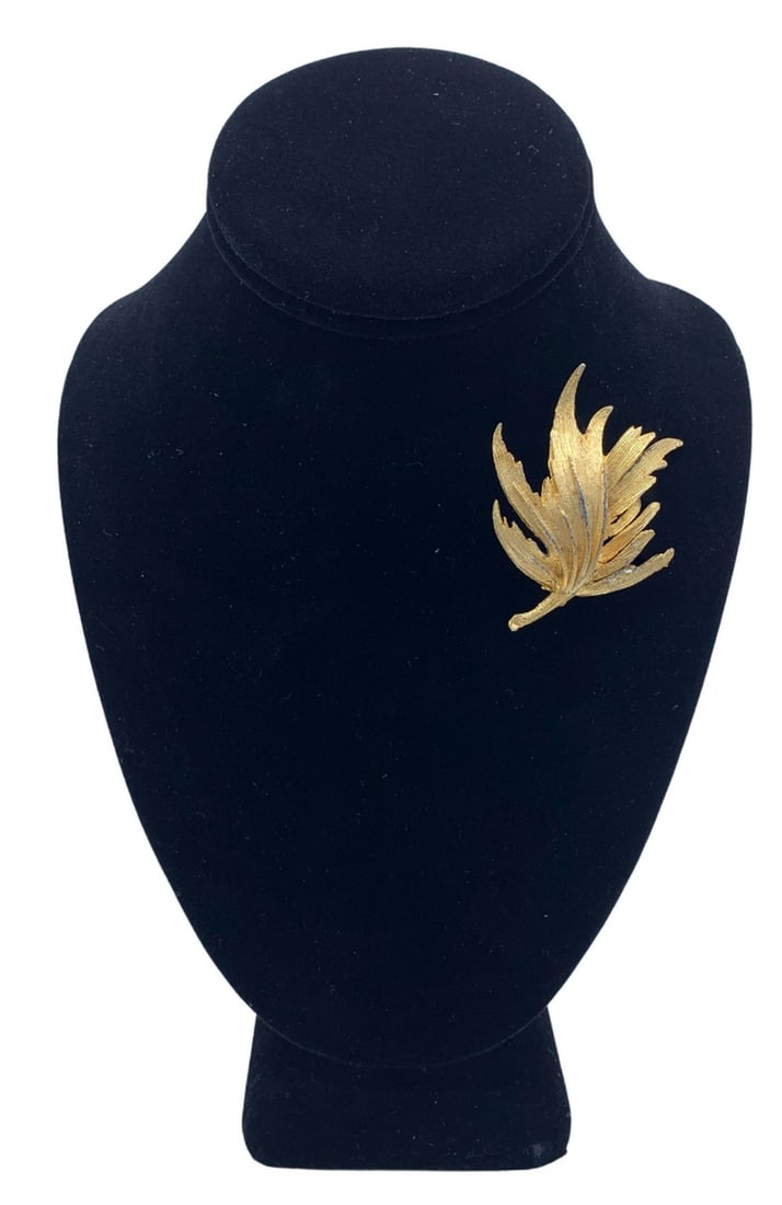 Gorgeous Gold Feather Brooch: Gorgeous Gold Feather Brooch As a symbol across many cultures, feathers have always represented a connection to spiritual realms and to divinity. And because of their connection to birds, they have