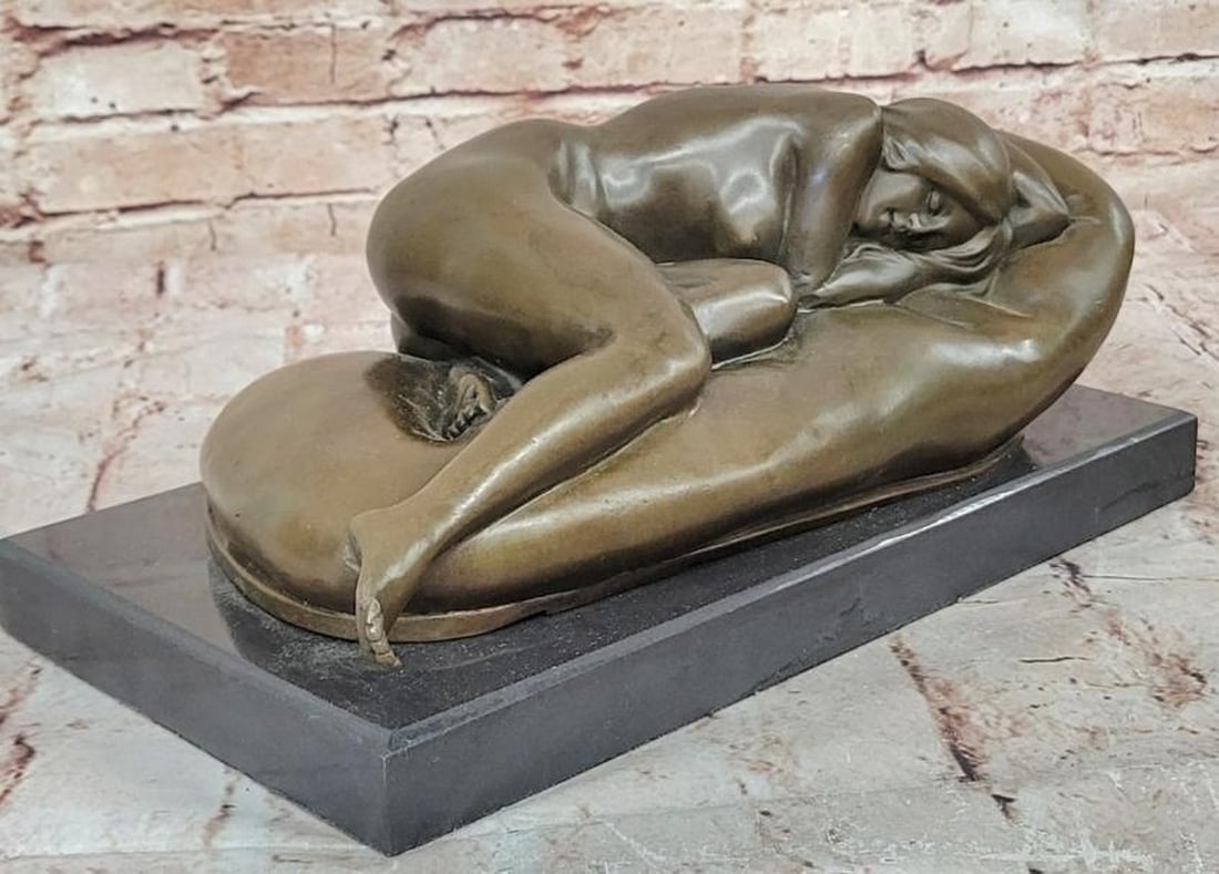 Silent Slumber: Bronze Nude Woman Resting: Silent Slumber: Bronze Nude Woman Resting Silent Slumber is a serene bronze sculpture capturing a nude woman in peaceful repose, her body gently curled on her side with arms tucked under her head in a