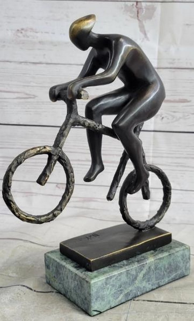 Momentum Cyclist Bronze Sculpture: Momentum Cyclist Bronze Sculpture Bold and minimalist, this is a compelling bronze sculpture of a cyclist athlete, finished in a sleek black patina that emphasizes form and motion. The rider is captur