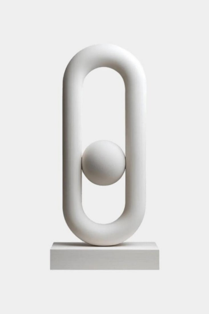 Oval Loop Sphere Sculpture: Oval Loop Sphere Sculpture A contemporary sculpture featuring a smooth elongated oval loop with a suspended central sphere that creates a striking sense of balance and harmony. Its clean lines, minima