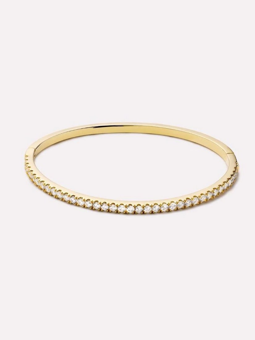 14K Gold-Plated Tennis-Inspired Bangle Bracelet: 14K Gold-Plated Tennis-Inspired Bangle Bracelet Inspired by the elegance of a classic tennis bracelet, this sleek gold bangle wraps your wrist in subtle sparkle and refined shine. Plated in 14K gold