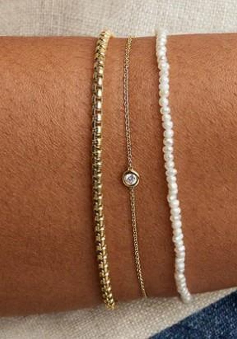 Micro Pearl Chain Bracelet: Micro Pearl Chain Bracelet A subtle strand of luminous micro pearls, this bracelet offers a refined take on classic elegance. Each tiny pearl is delicately spaced along a fine chain, creating a