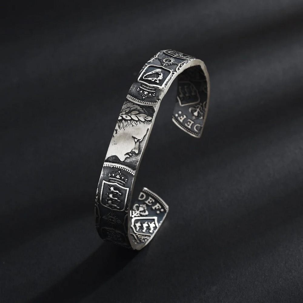 Queen's 1953 Silver Coin Bangle: Queen's 1953 Silver Coin Bangle Handcrafted from 1953 Queen's silver coins, this bangle pays tribute to a defining moment in royal history. Coins are selected for their finest details, then skillfully