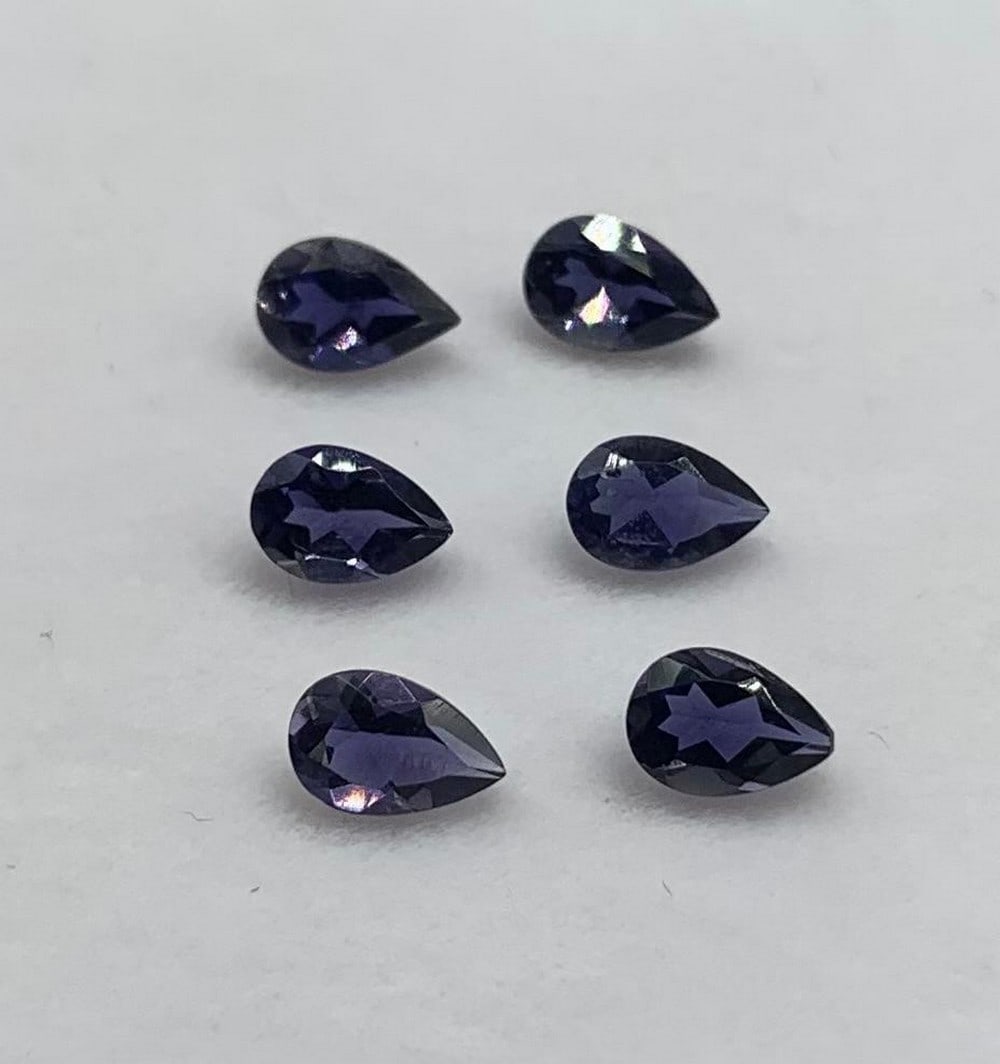 Six 0.34ct Pear Facet Indigo Iolite Gemstones: Six- 0.34ct Pear Facet Indigo Iolite Gemstones The facets reflect and refract light, showcasing the gemstone's deep indigo hue from every angle. Whether set in a pendant, ring, or earrings, these gems