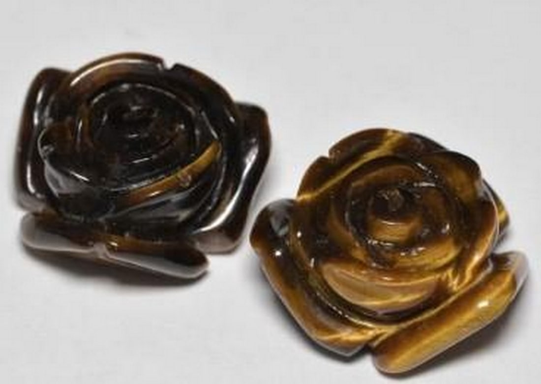 25.60ct Sunlit Bloom Tiger's Eye Flower Gemstone: 25.57ct Sunlit Bloom Tiger's Eye Flower Gemstone This 25.57ct tiger's eye dazzles with its warm brown tones and characteristic chatoyant shimmer. Cut into a delicate flower shape, the opaque gemstone 