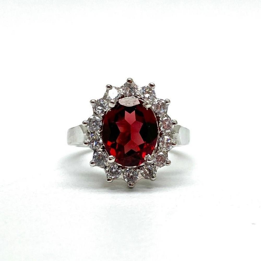Garnet Gemstone Ring in a Halo Setting Surrounded by Austrian Crystals on a 925 Sterling Silver Band: Garnet Gemstone Ring in a Halo Setting Surrounded by Austrian Crystals on a 925 Sterling Silver Band. Garnets symbolize love and friendship. They represent the heart, inner fire, and are considered to