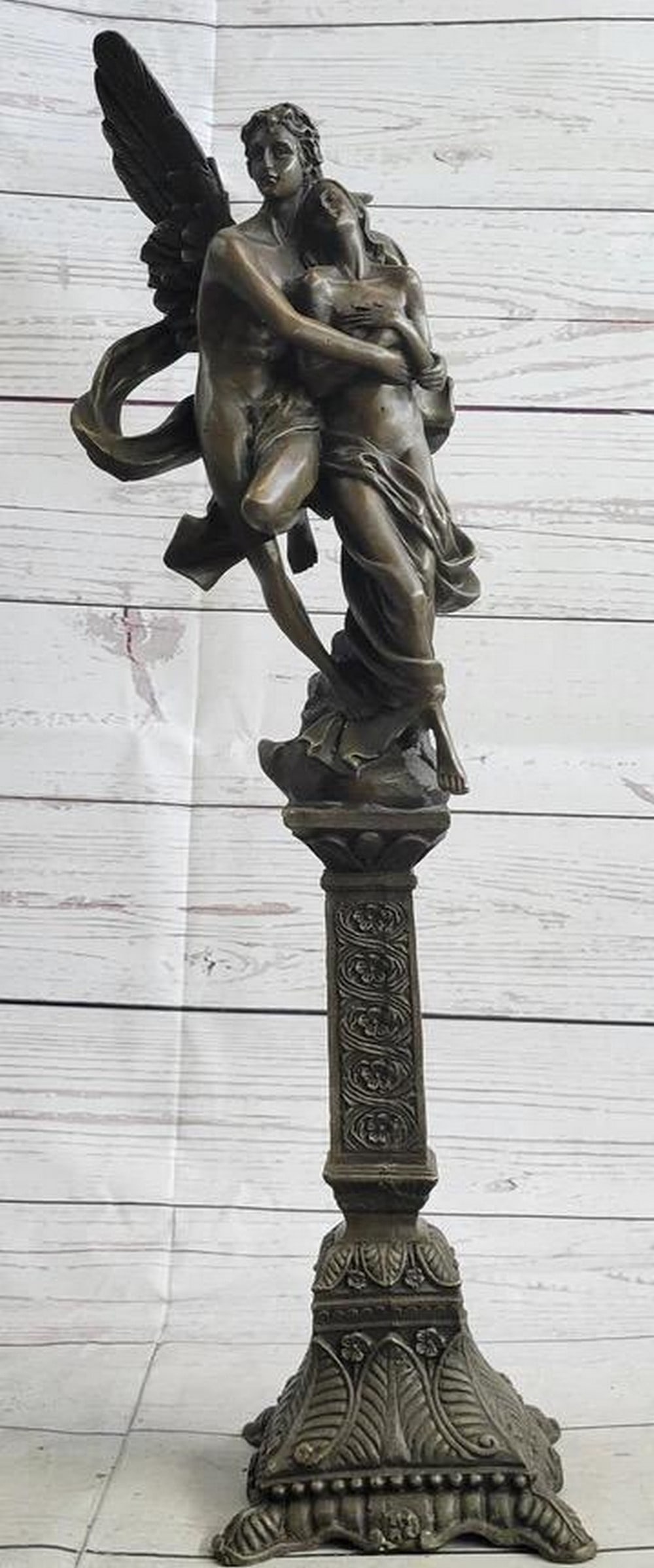 Guardian Angel Cradling Women Inspired Bronze Statue - 19'' x 5'': Guardian Angel Cradling Women Inspired Bronze Statue - 19" x 5" In this poignant bronze sculpture, a nude male angel tenderly cradles a girl in his arms, creating an intimate and vulnerable mome
