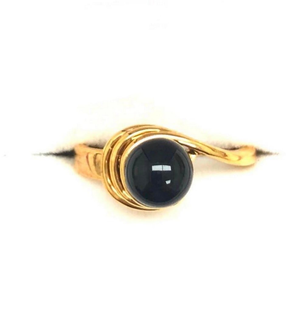 Onyx Gemstone In 18KTGP Yellow Gold Electroplate Finish Ring: Onyx Gemstone In 18KTGP Yellow Gold Electroplate Finish Ring. This elegant ring features a striking black onyx gemstone set in a polished 18KT yellow gold electroplated band. The deep, glossy onyx