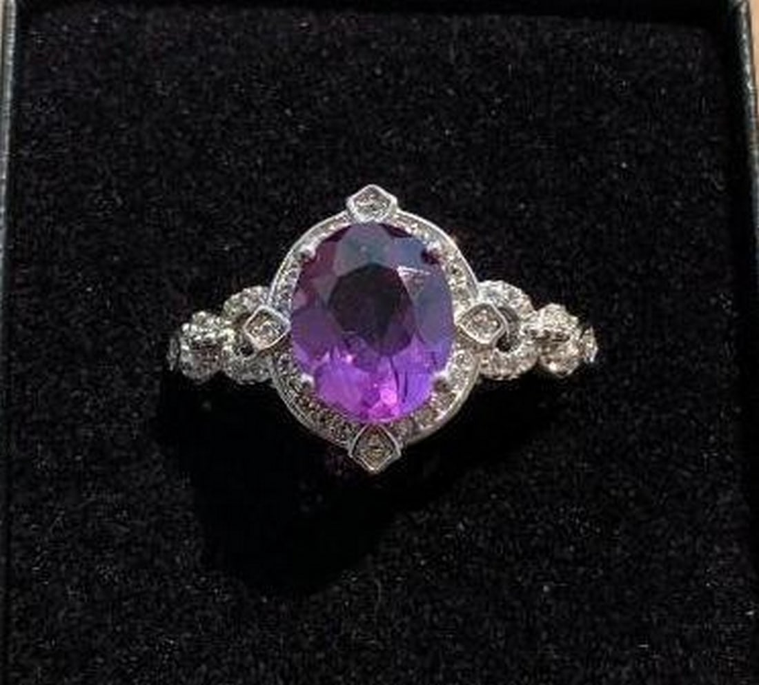 Sterling Silver Oval Purple Stone Ring: Sterling Silver Oval Purple Stone Ring This exquisite sterling silver ring features a captivating oval-shaped purple stone at its center, surrounded by delicate, intricate designs in the silver band.