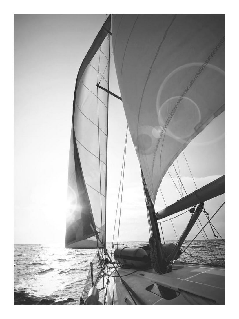 Twilight Sail Poster: Twilight Sail Poster A black and white print of a sailing boat navigating the rough sea toward the horizon and setting sun. The hoisted sails and blowing wind capture the motion and spirit of the