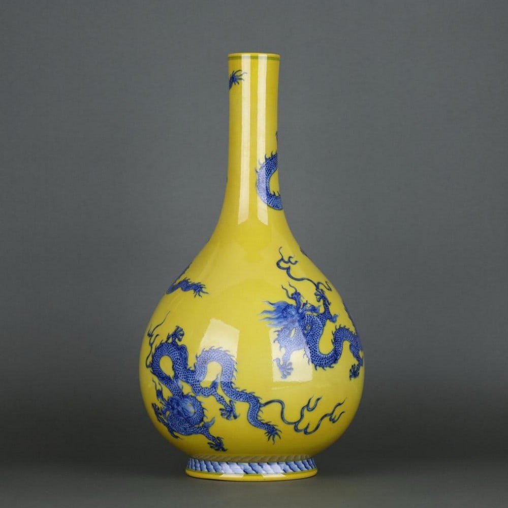 Qing Qianlong Yellow Glaze Blue and White Five-Dragon Pattern Bottle: Qing Qianlong Yellow Glaze Blue and White Five-Dragon Pattern Bottle A finely crafted bottle from the Qianlong period of the Qing Dynasty, featuring a striking yellow glaze accented with classic blue 