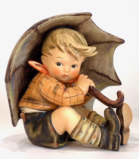 hummel boy walking with umbrella