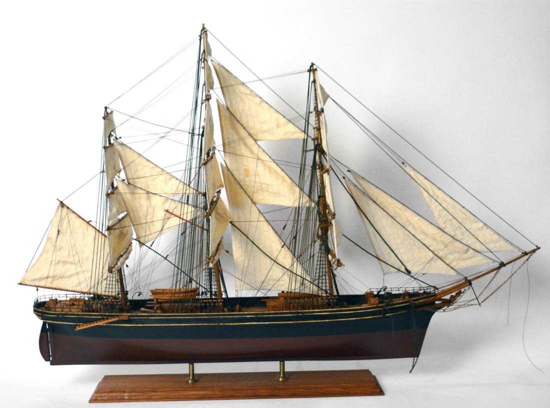 Ship Model on Stand: Wooden ship model with fabric sails, carved figural masthead. 27"H. x 40"L x 6"D. Guest House Great Room. NO RESERVE. This lot was formerly the property of well-known real estate developer Mr. Melvin