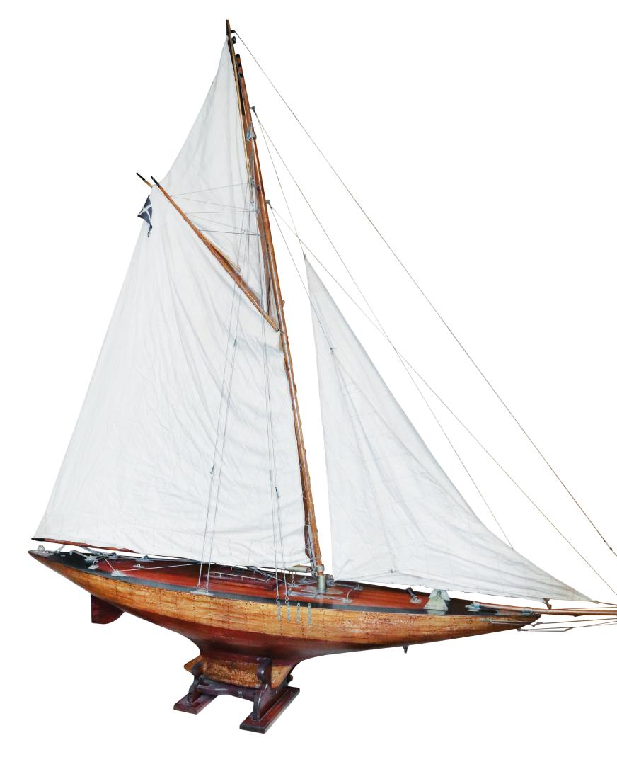 Vintage Pond Yacht: Eight foot vintage gaff rigged pond yacht with a full suit of sails, including jibs and a flying club, and a planked and varnished hull with brass fittings. Sitting in a wooden cradle. The successful